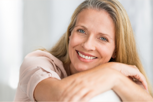 Smiling mature woman appearing relaxed, symbolizing improved mood after red light therapy
