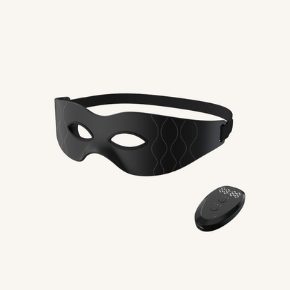 Black eye mask with a remote control on a white background
